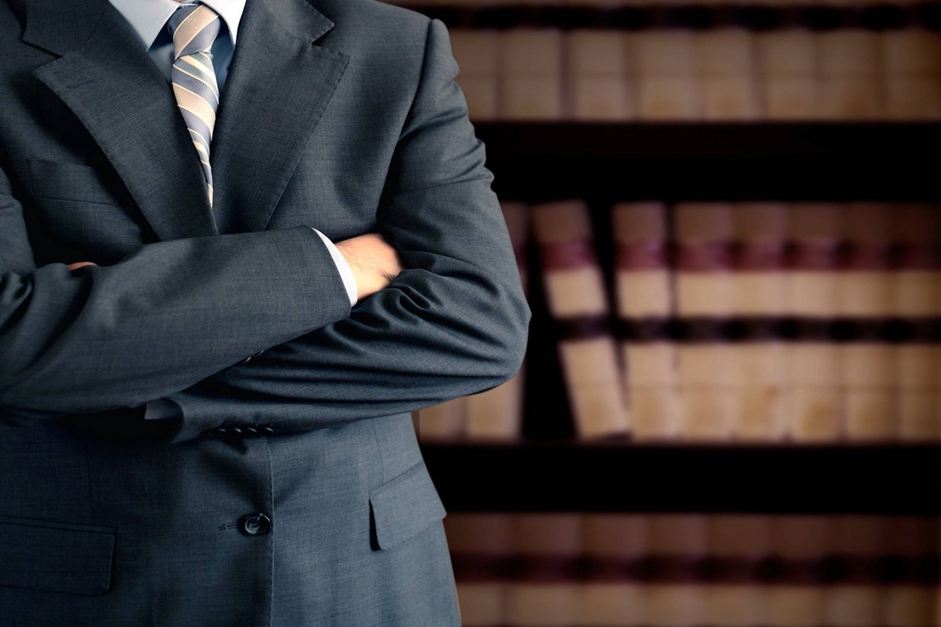 Un professionista in abito scuro davanti agli scaffali dei codici